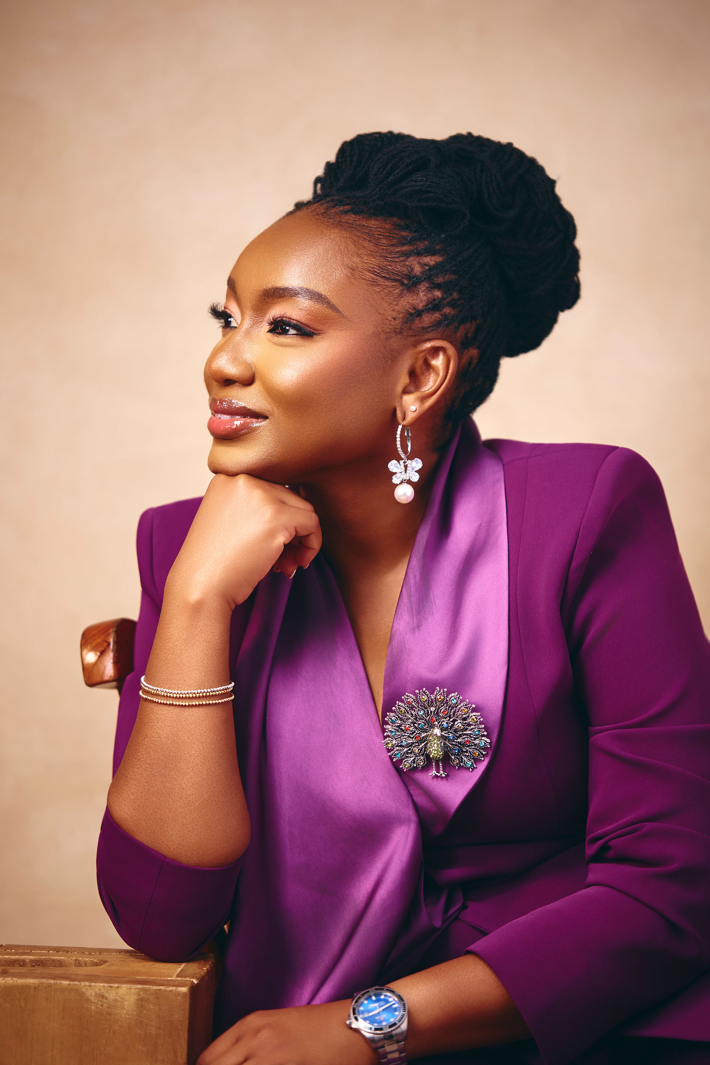 Aramide Balogun seated, wearing a purple satin blazer